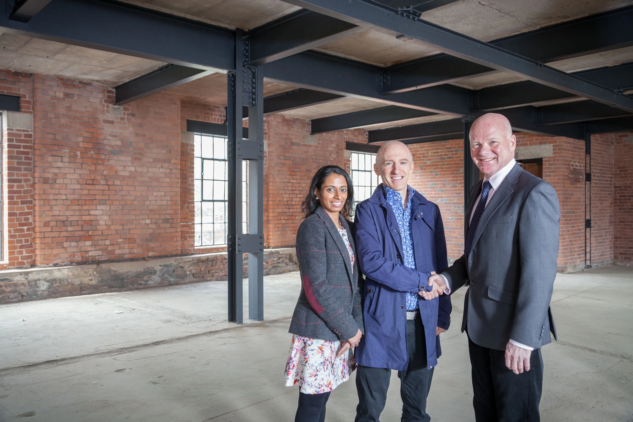 Taylor&Emmet commercial property specialist, Alastair Reid (right), congratulates The Milestone Group's Nina Patel-Bigland and Matt Bigland on securing Rutland Cutlery Works.