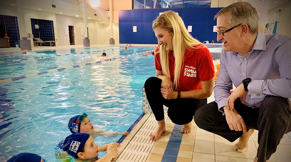 (L to R) Britain’s most successful swimmer Rebecca Adlington and Nuffield Health Senior Manager Paul Burnham with local children enjoying a SwimStars taster session in Gosforth. 