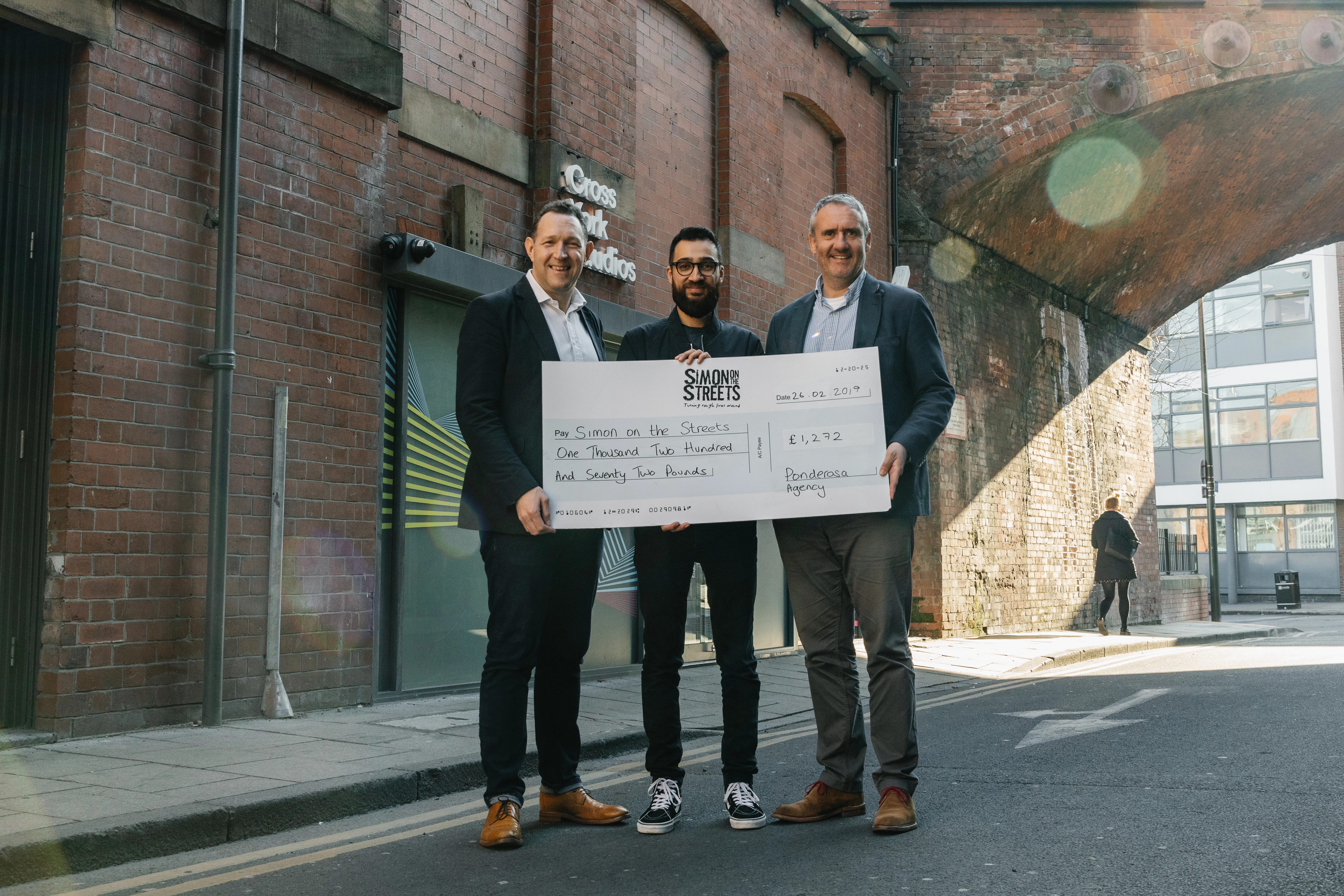 Ponderosa's Steve Henry and Richard Midgley presenting the cheque to Fahad Khan from Simon on the Streets