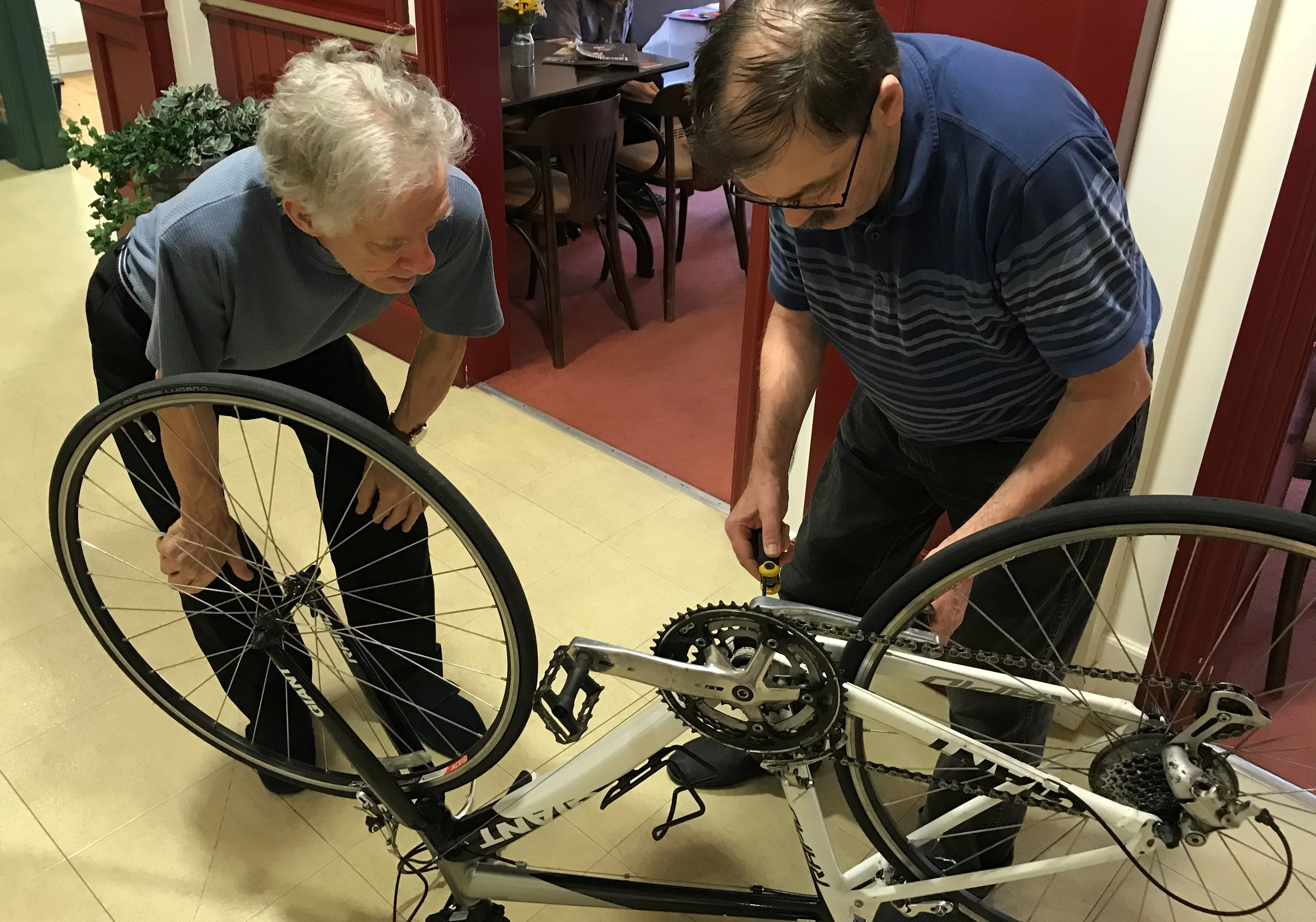 Stephen Baylis and John Bossom working to fix bikes donated by Hewitt Cycles