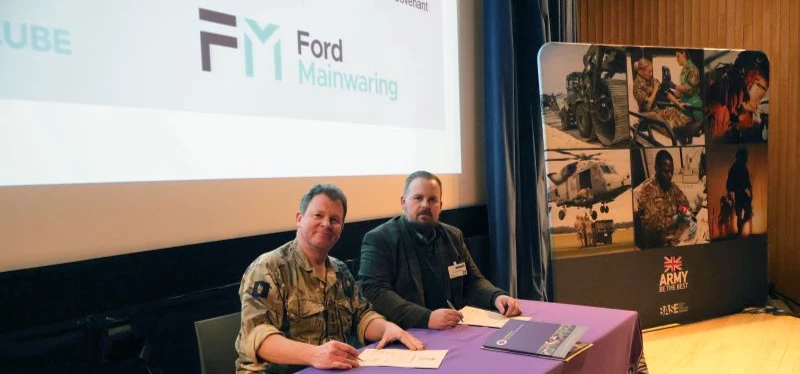 Colonel Sam Plant MBE and Daniel Bailey sign Ford Mainwaring's Armed Forces Covenant pledge .