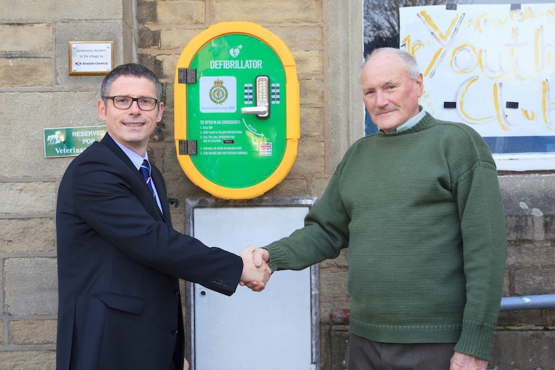 Airedale Chemical's Daniel Fox and Glusburn Parish Council's chair Philip Baker with the newly installed defibrillator