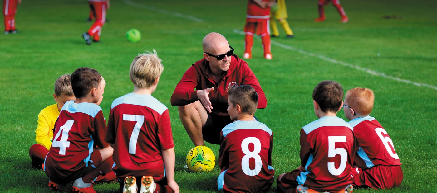 Football coach talks to schoolchildren