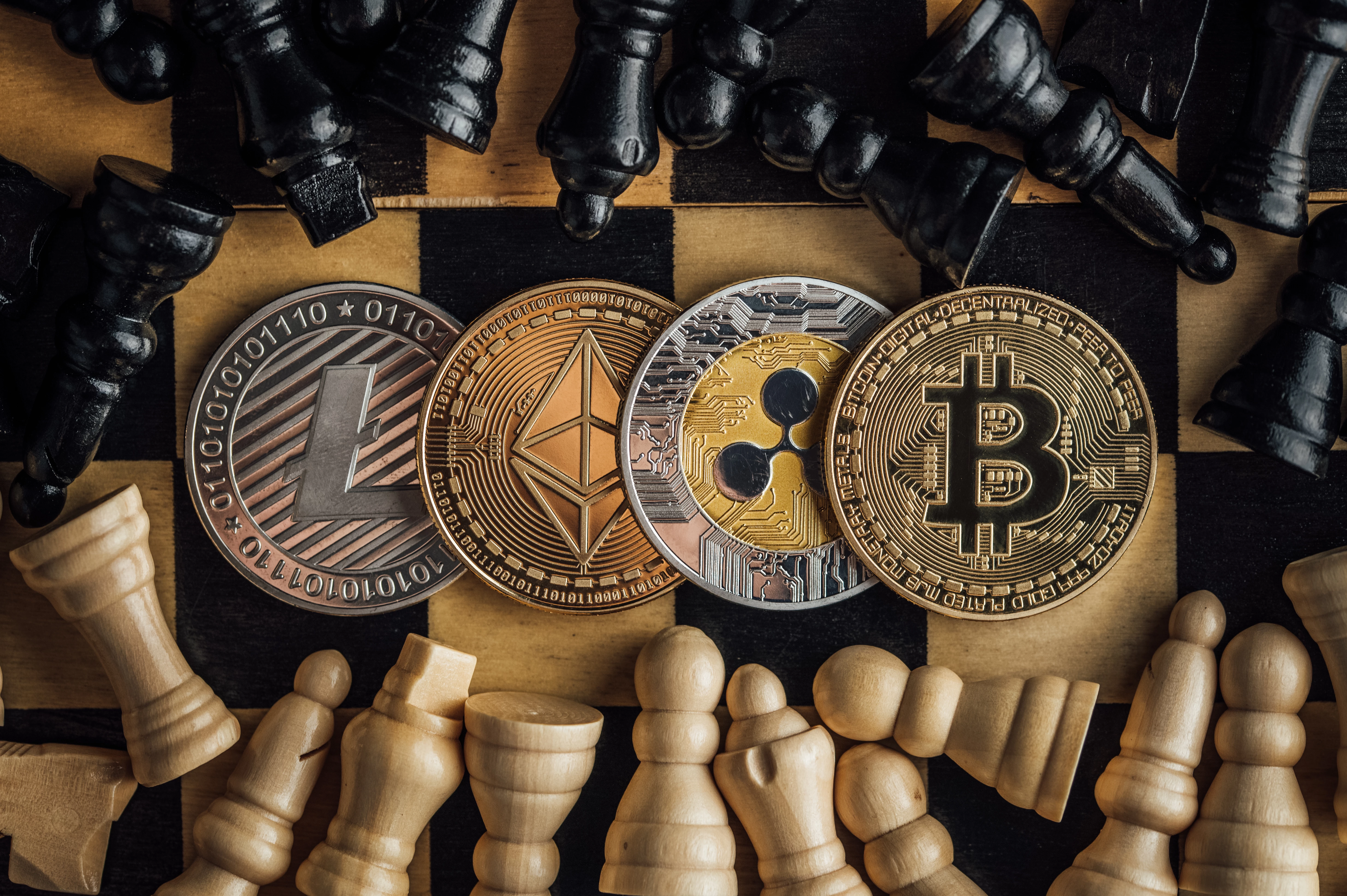 Bird's eye view of the physical crypto currency coins surrounded by chess pieces
