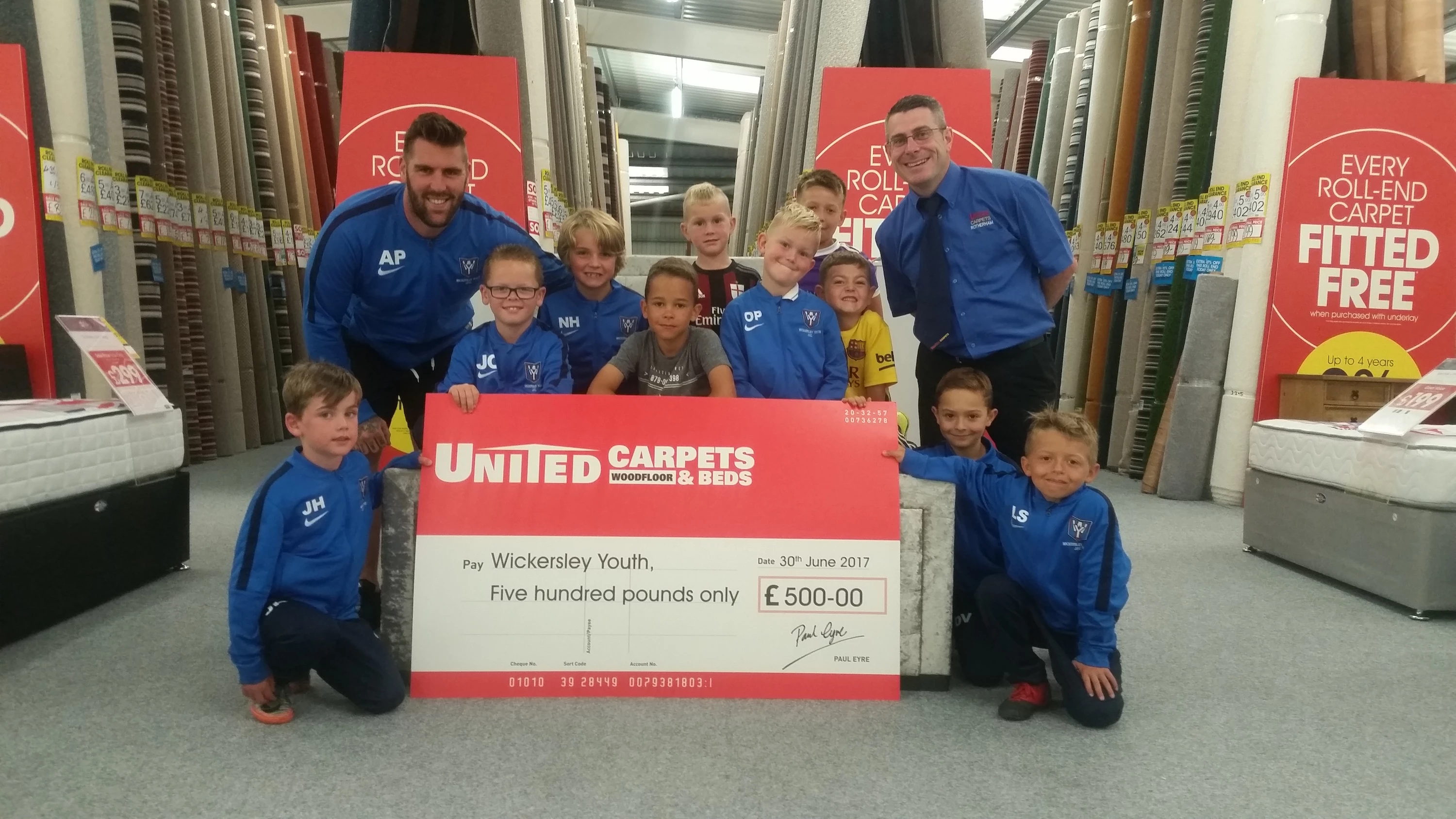 L-R Alex Pearman (Wickersley Under 8s Coach), the team and Jason Swift (Rotherham United Carpets & Beds store manager)