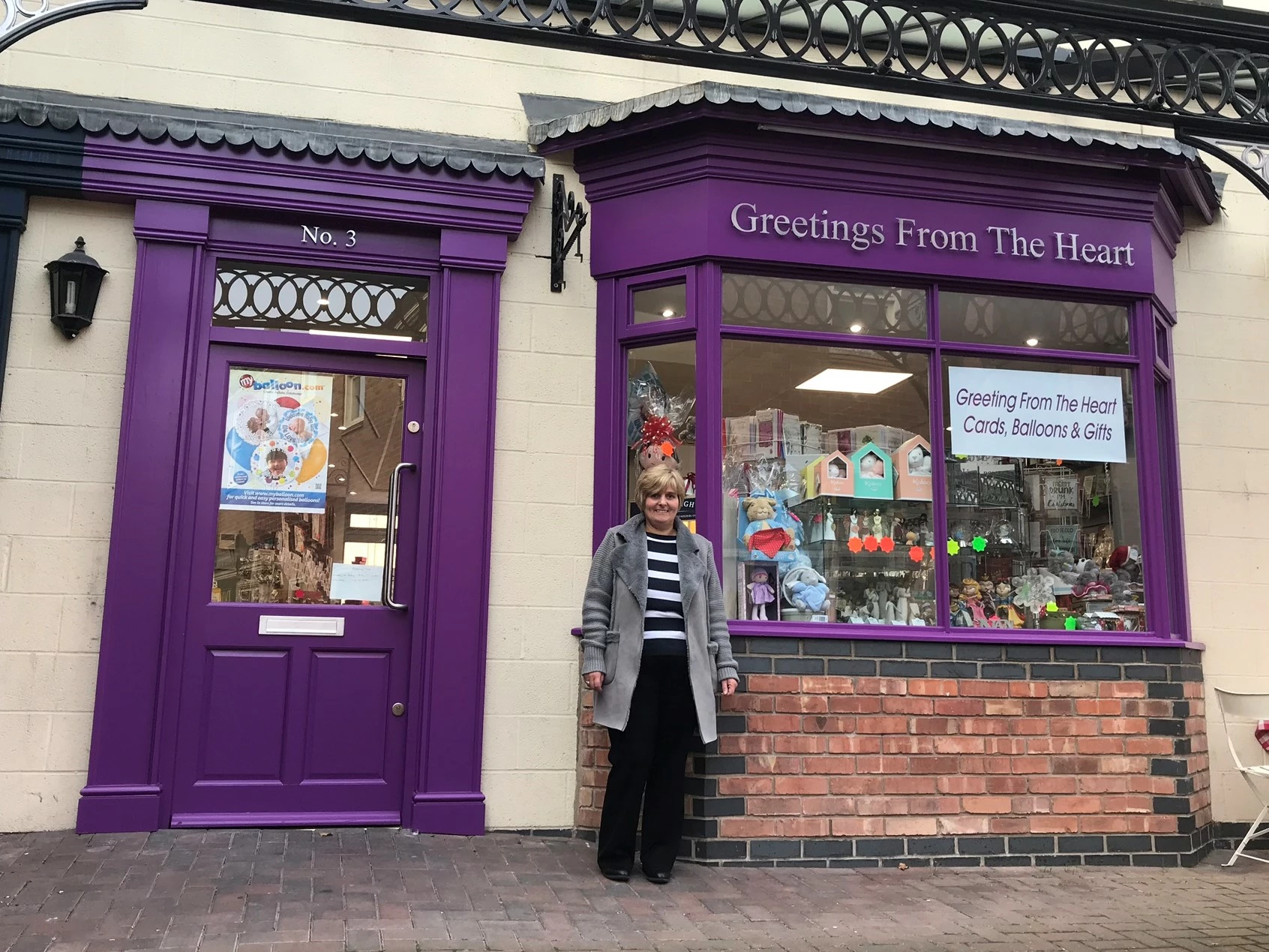 Mandy Scrivens in front of Greeting From The Heart 