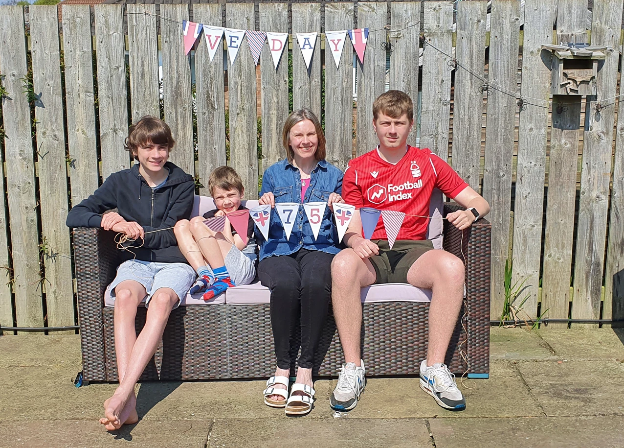 Catherine Lines, with sons (l-r) Charlie, Samuel and Ciaran, show off the All About Words VE Day Celebration Bunting