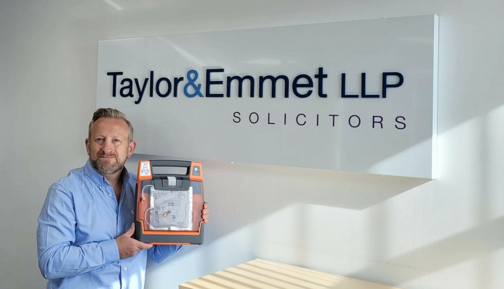 Taylor&Emmet's facilities manager, Lee Stacey, with one of the defibrillators purchased by the firm. 